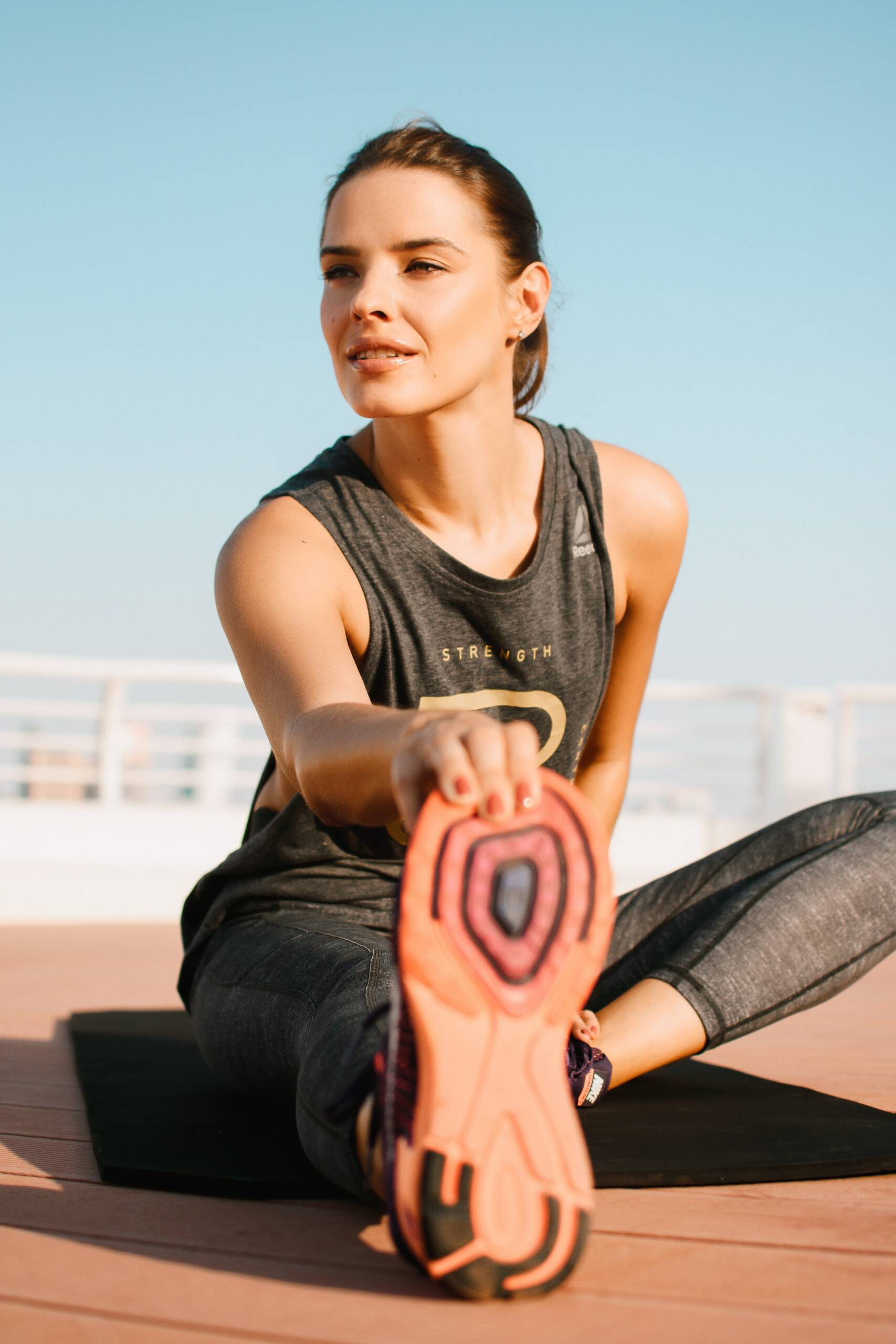 Beautiful sport girl athlete performing warmup stretching in sport wear