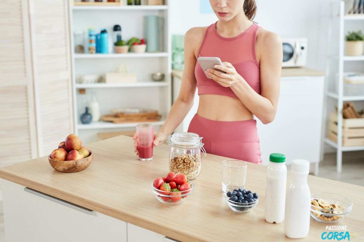 Donna con il telefono in mano che fa uno spuntino