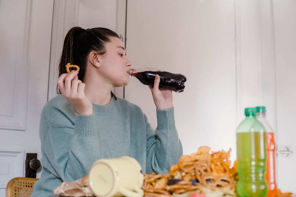 Donna con cibo e bevande spazzatura 